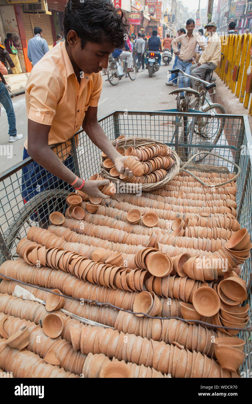 Indien, Uttar Pradesh, Varanasi, einem deliveryman entlädt Ton Tassen, verwendet Chai zu dienen, von einem Fahrrad Anhänger. Stockfoto