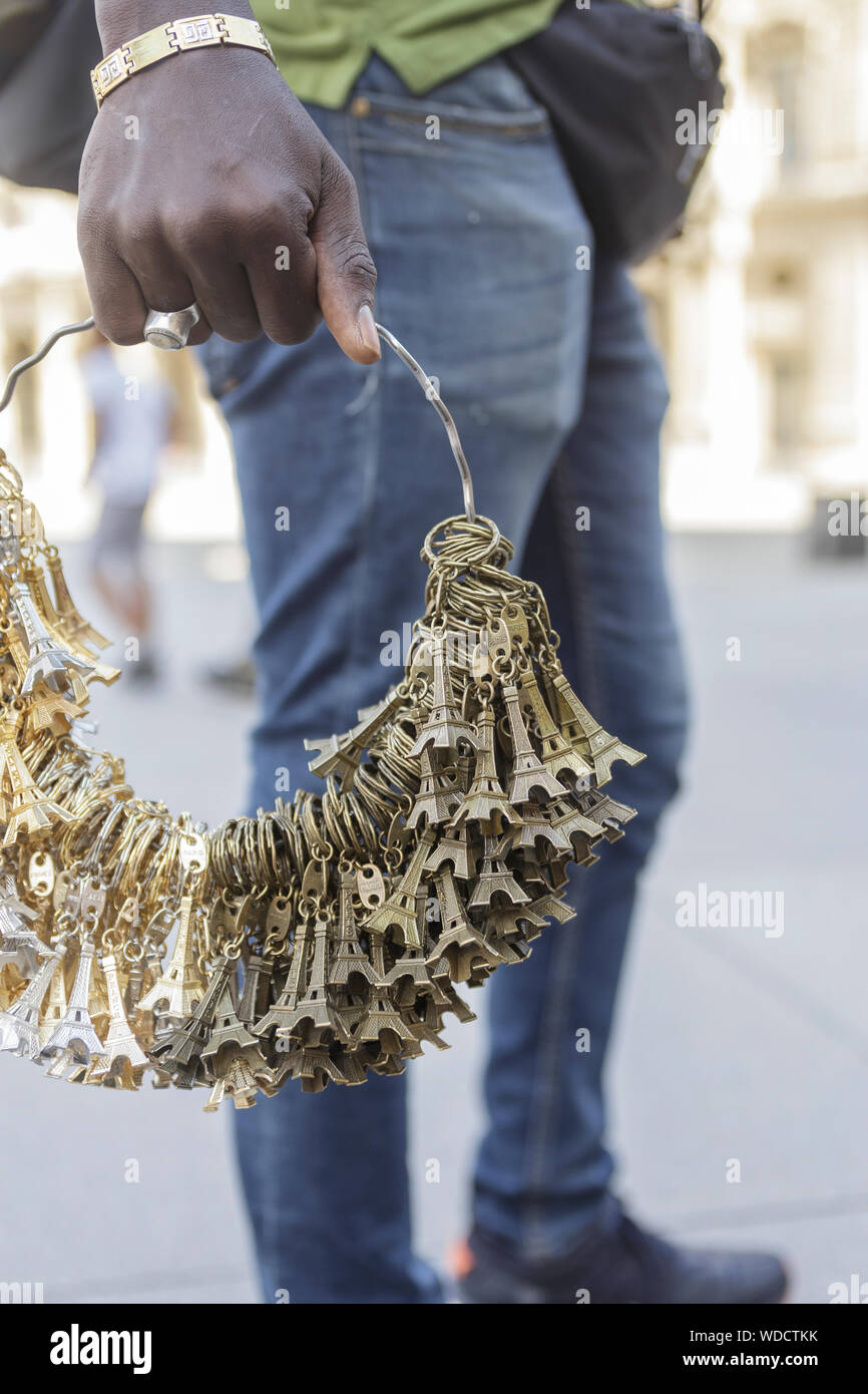 Ein Verkäufer auf den Straßen von Paris mit dem Eiffelturm Trinkets. Stockfoto