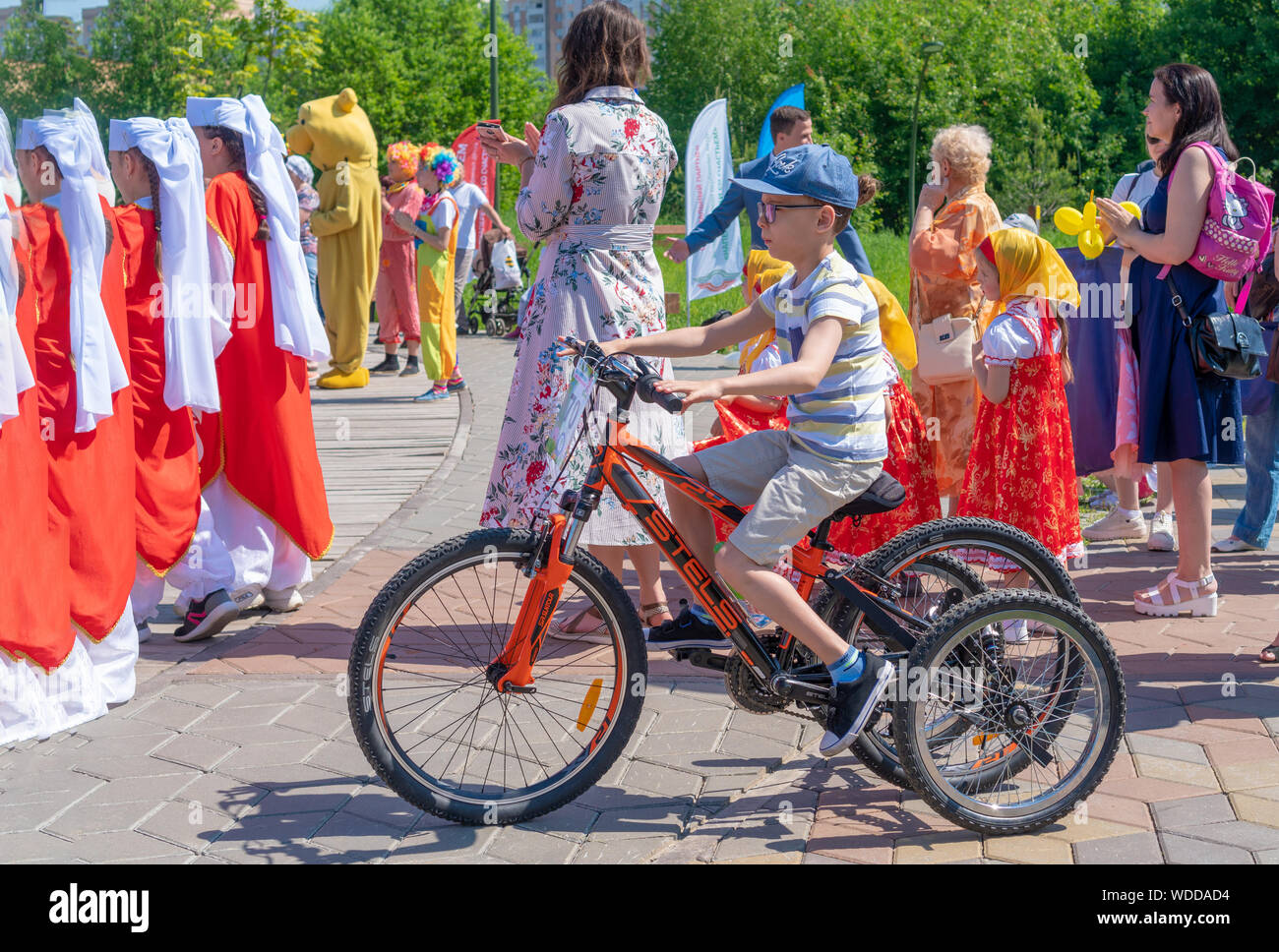 Russland, Kazan - Mai 31, 2019: Behinderte Junge mit Brille auf ein Vierrädriges Fahrrad auf einem hellen, sonnigen Tag. Charity Radtour. Der Eintritt ist frei. Stockfoto