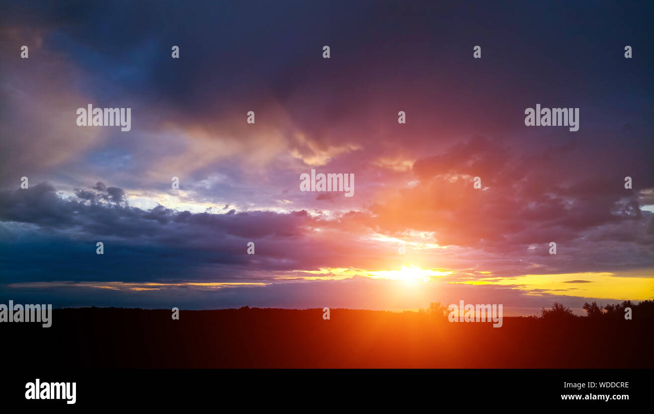 Die hellen und farbenfrohen Sommer Sonnenuntergang auf dem Hintergrund der bewölkt, Gewitterwolken. Stockfoto