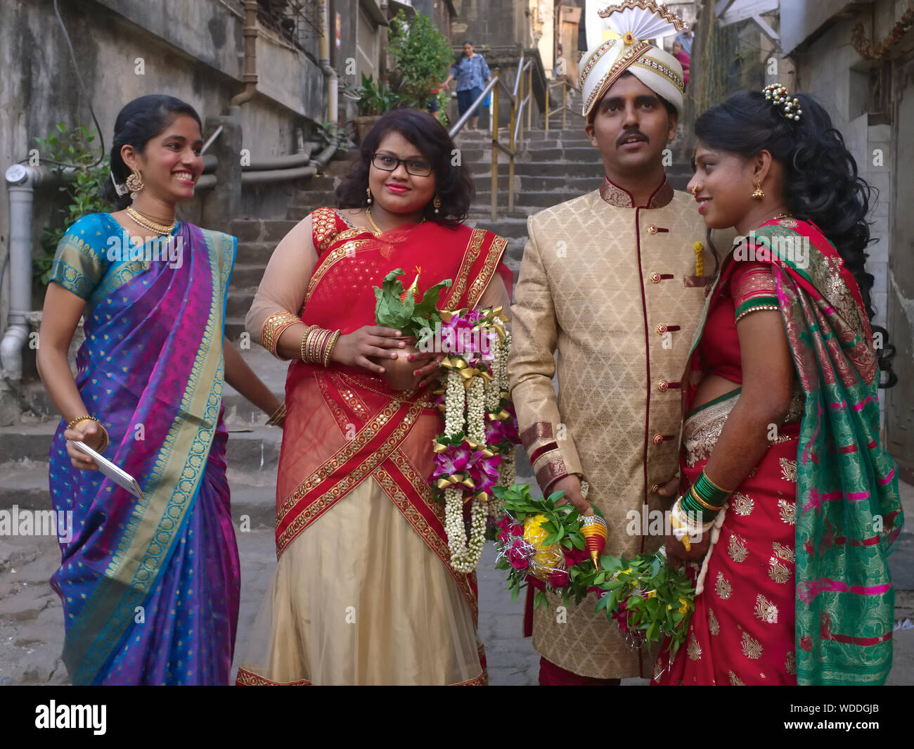 Eine low-key Hochzeitsfeier in Mumbai, Indien, die festlich gekleidet Hochzeit paar (r) und Freunde in Hinterhof des Paares Stockfoto