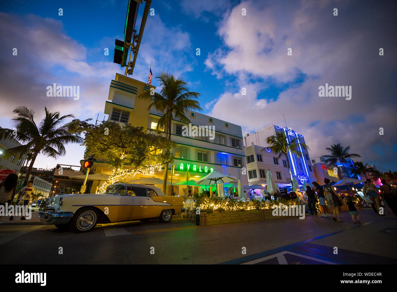 MIAMI - Januar 08, 2018: Neon Lichter schmücken die Art Deco Architektur hinter einer klassischen amerikanischen Auto am Ocean Drive in South Beach geparkt. Stockfoto