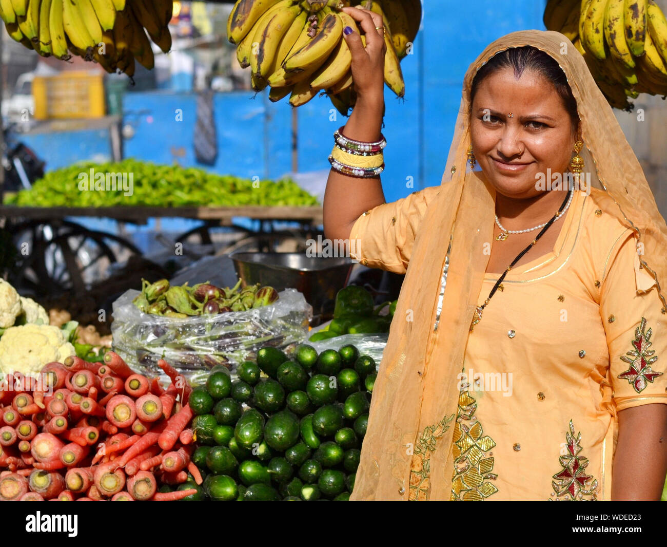 Indische Rajasthani markt Frau, gekleidet in einen wunderschönen Sari, verkauft Gemüse und Bananen. Stockfoto