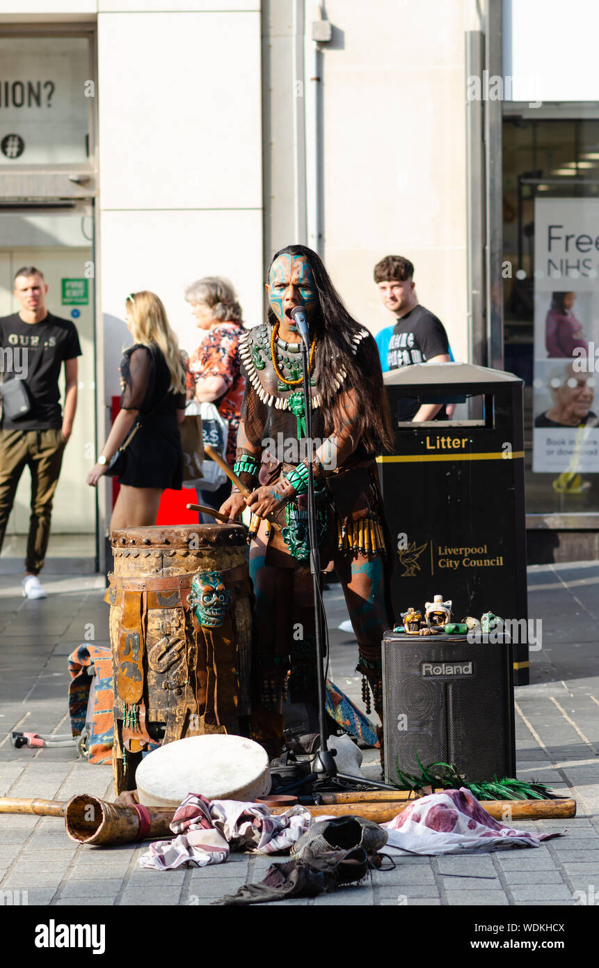 Mayan Krieger spielt die Trommel. Ritual Maya theater Künstler aus Mexiko auf der Straße von Liverpool. Der Künstler trägt den traditionellen Maya Kostüm. Stockfoto