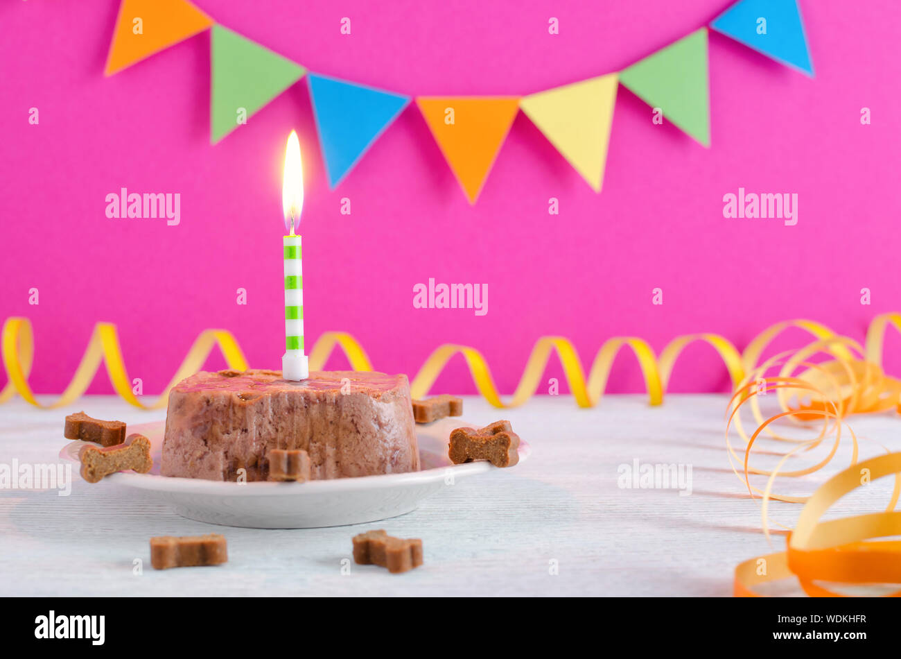 Happy Birthday Kuchen für Hund von Nassfutter und behandelt mit Kerze für Pink party Hintergrund Stockfoto
