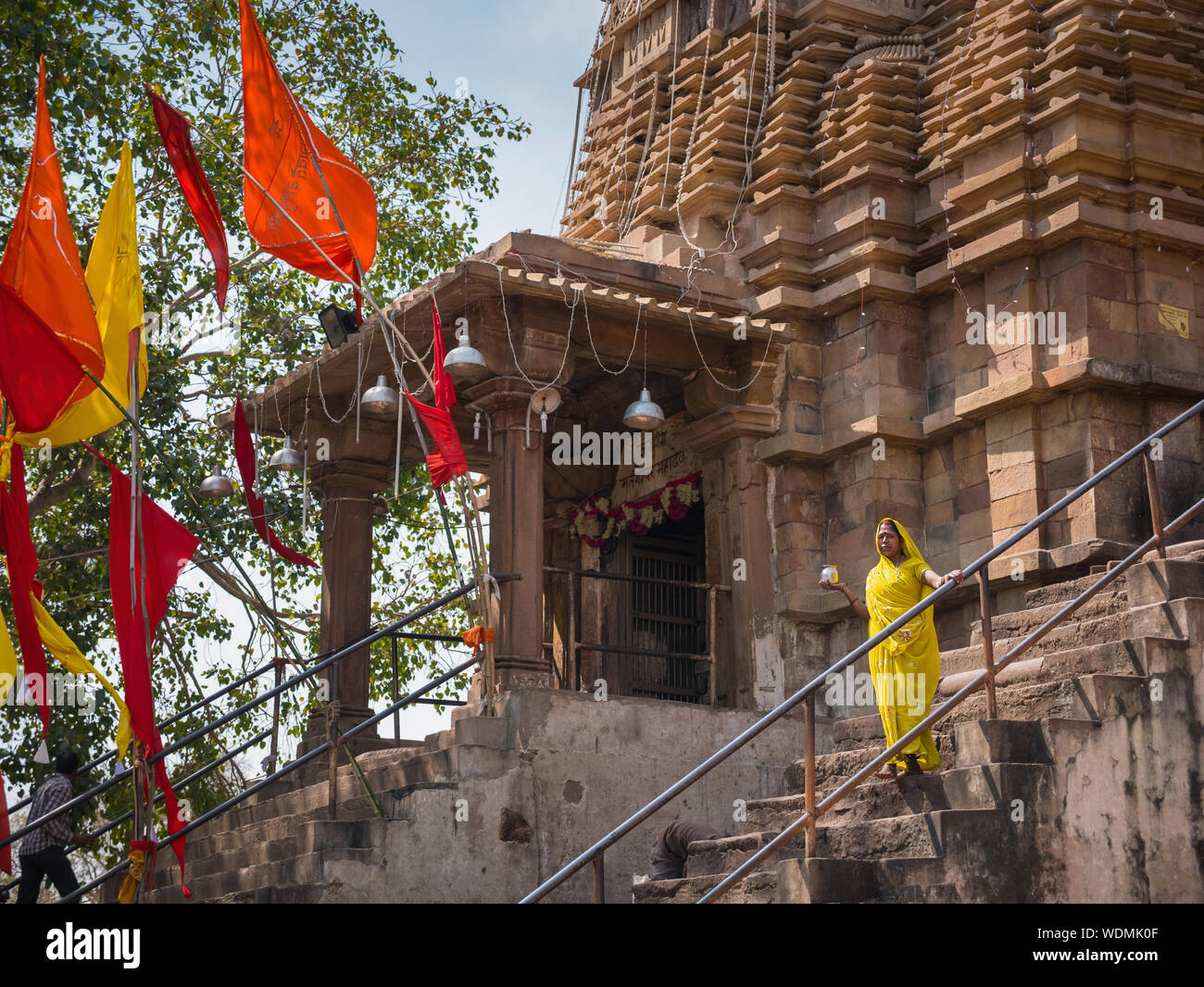 Indische Frau in einem gelben Sari, stehend vor Matangeshvara Tempel, Khajuraho Gruppe von Denkmälern, Khajuraho, Madhya Pradesh, Indien, Asien Stockfoto