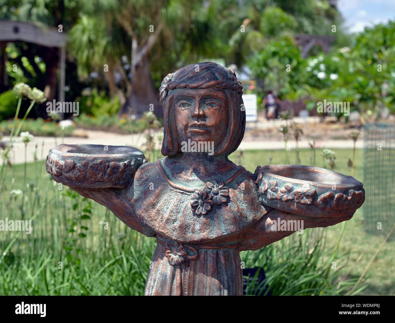 Bronzestatue mit grüner Patina der Jungfrau Holding eine Schüssel in jeder Hand. South Texas Botanical Gardens and Nature Center. Corpus Christi, Texas USA. Stockfoto