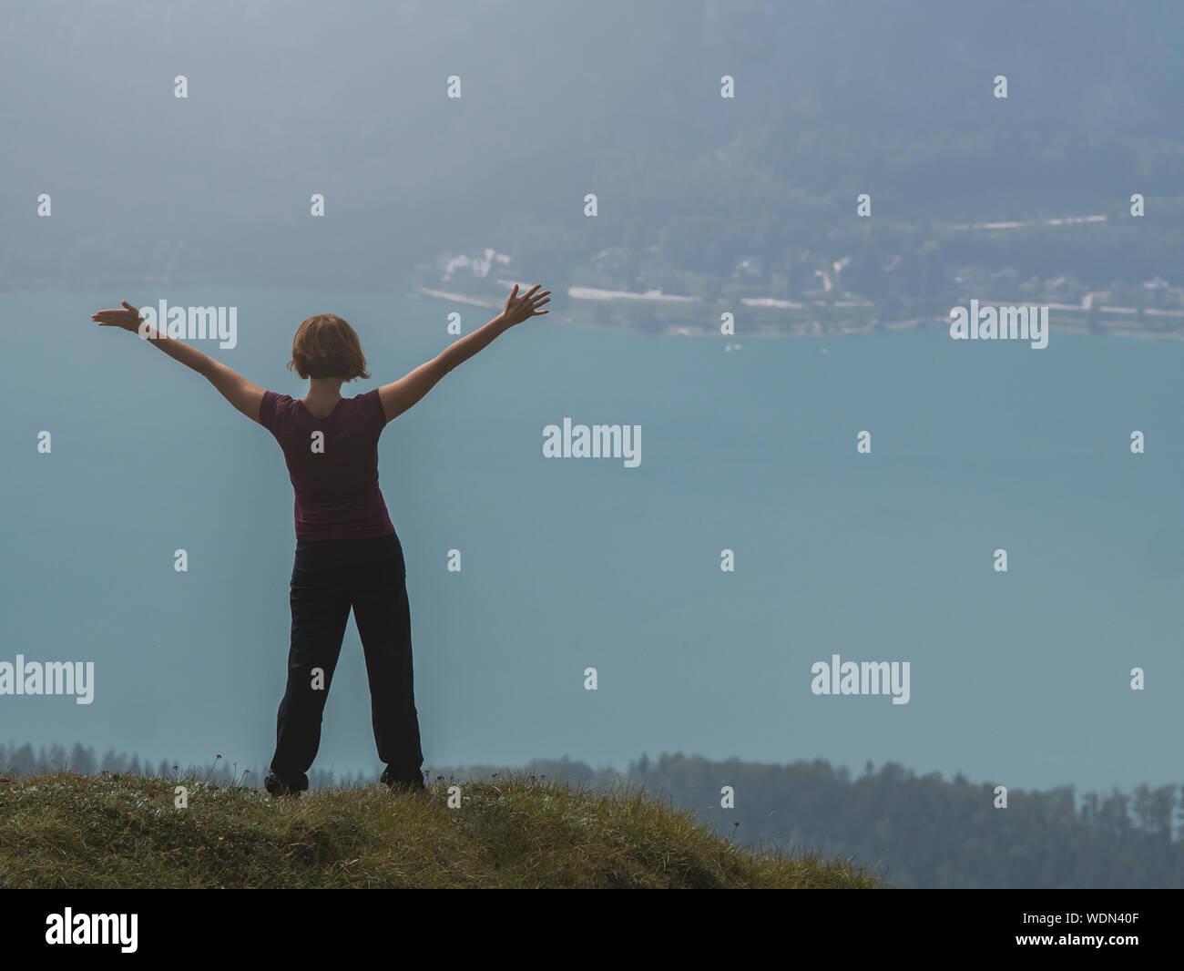 Glückliche junge Frau stand auf einem Berg Stockfoto