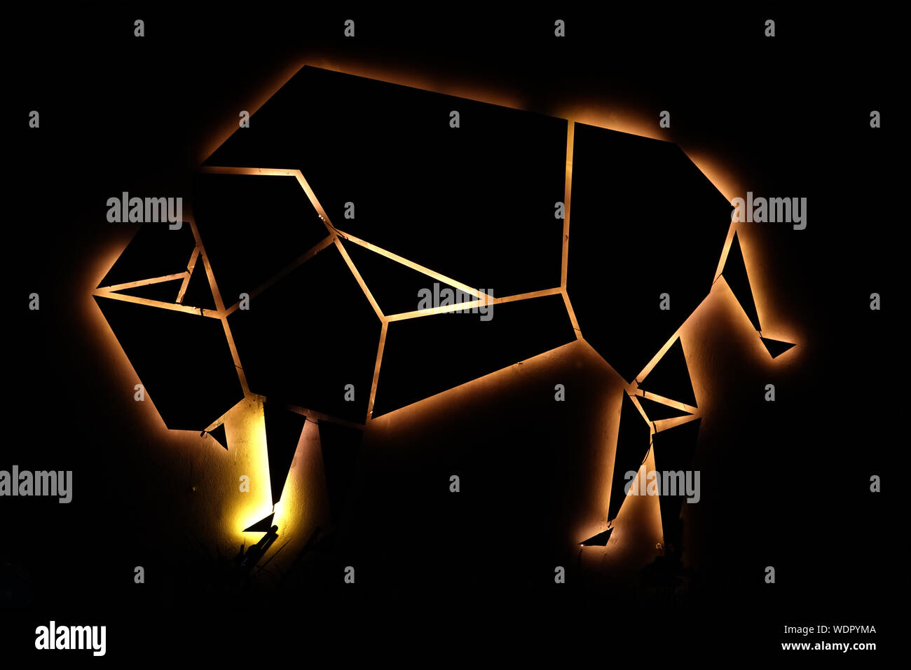 Glühende Leuchtreklame eines Stieres mit dunklem Hintergrund. Geeignet für Licht und Energie Themen. Stockfoto