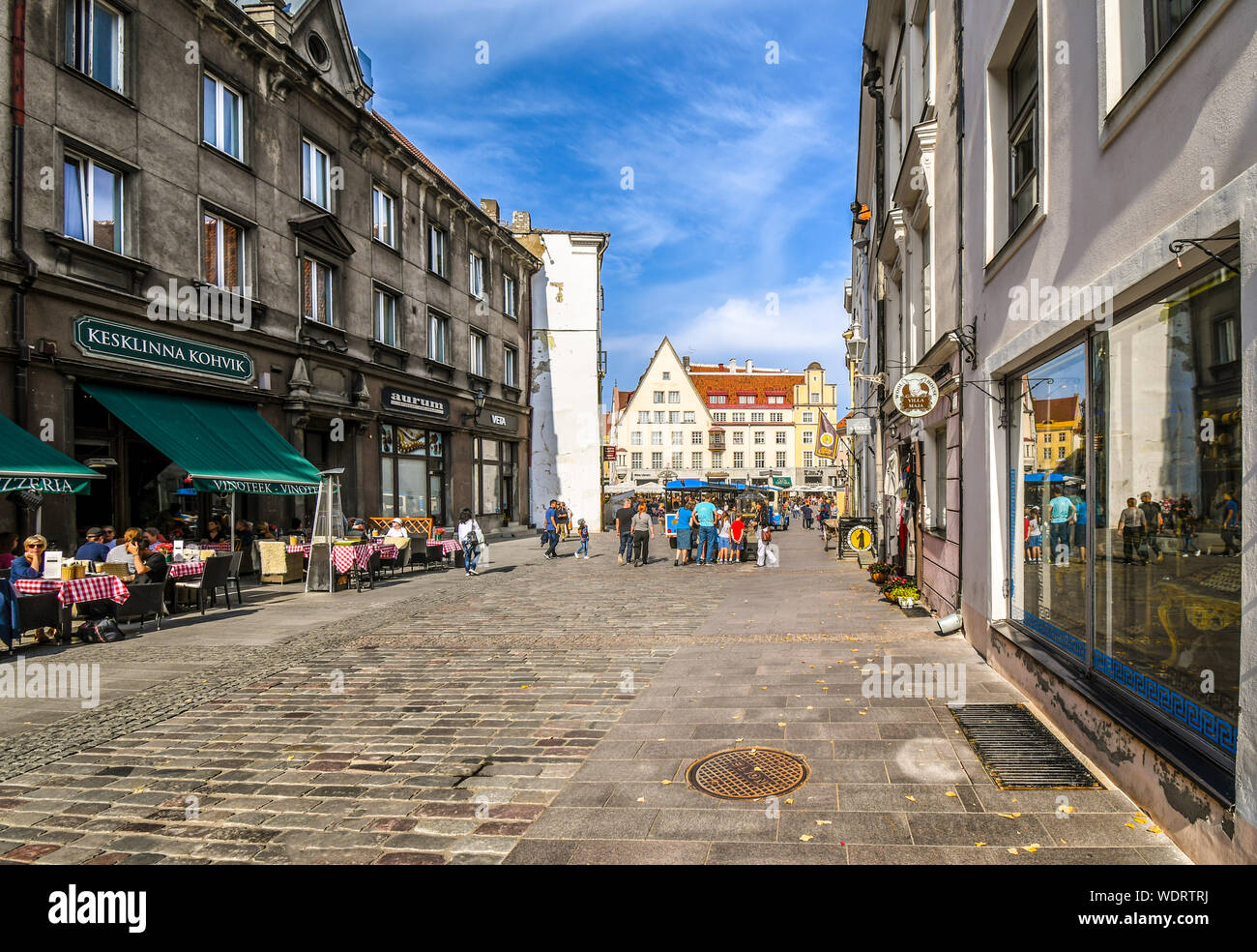 Touristen in ein straßencafe auf einer breiten Straße in Richtung Rathausplatz an einem Sommertag in der mittelalterlichen Baltischen Stadt Tallinn Estland Stockfoto