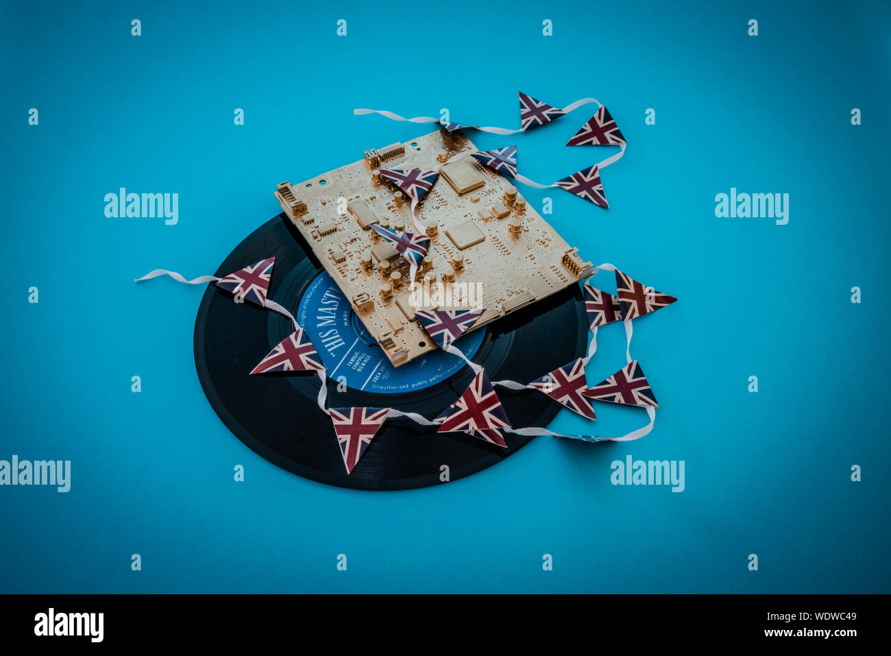 Alte vinyl singles Datensätze mit einem gold Computerplatine und Union Jack mini Bunting Stockfoto