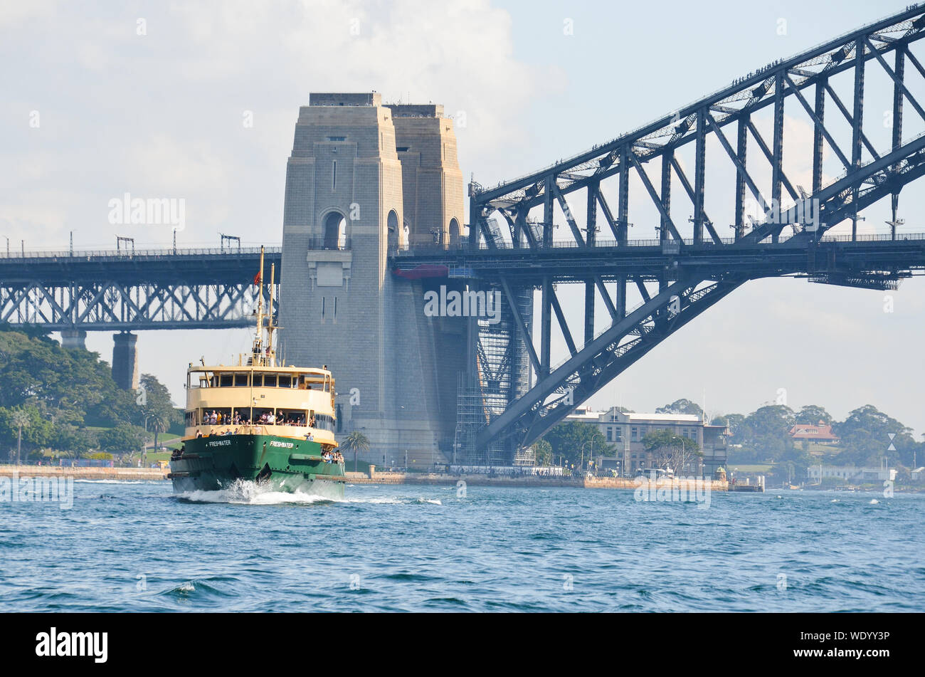 Schöne Aussicht auf den Hafen von Sydney mit Manly Fähre und Sydney Harbour Bridge im Hintergrund an einem sonnigen Tag. Stockfoto