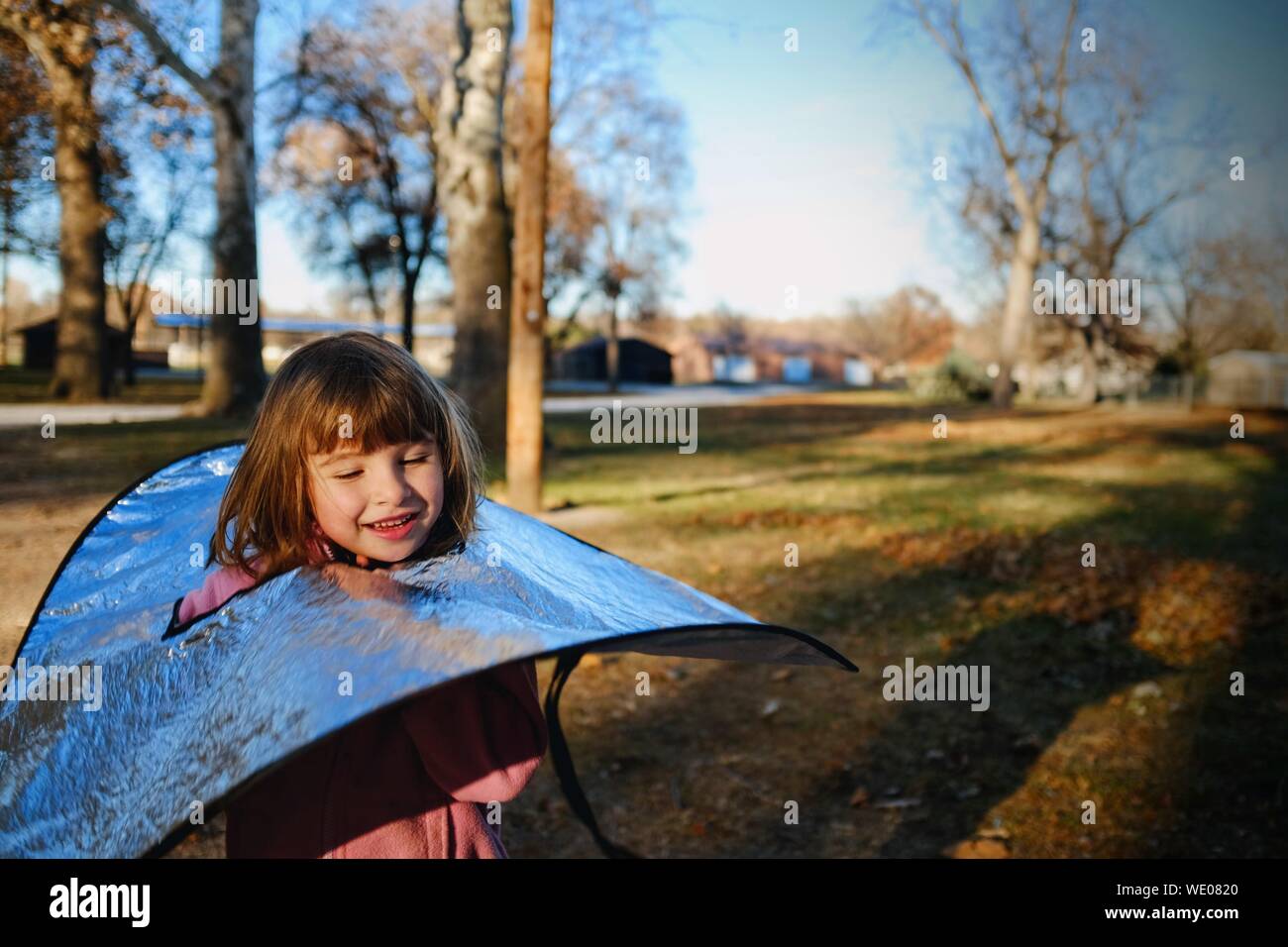 Nahaufnahme der lächelnde Mädchen mit Reflektor in Park Stockfoto
