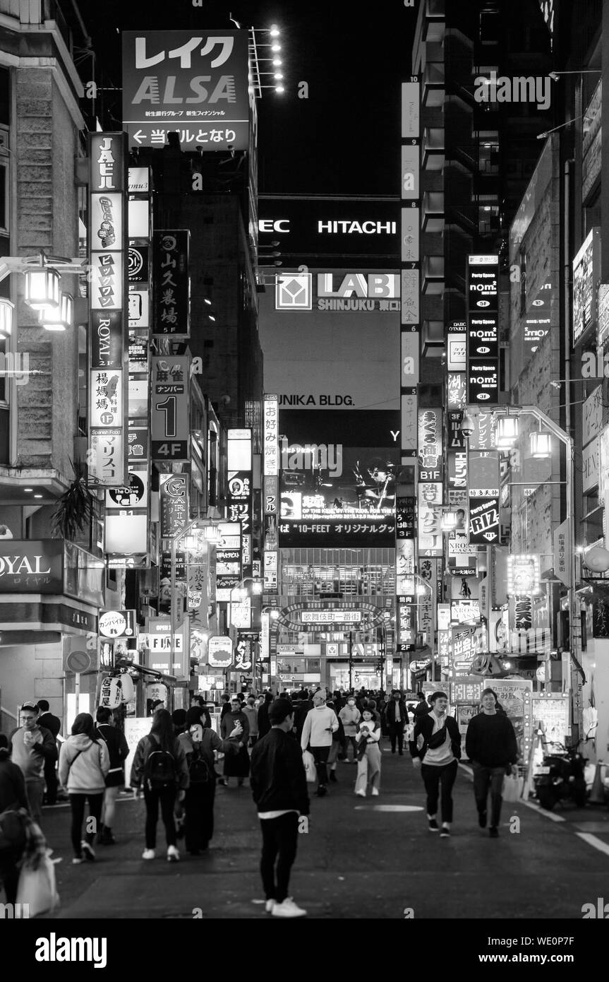 DEC 4, 2018 Tokyo, Japan - Shinjuku bei Nacht pulsierende belebten Straße Nachtleben mit vielen lightbox Zeichen, viele Völker wandern auf schmalen Straße Stockfoto