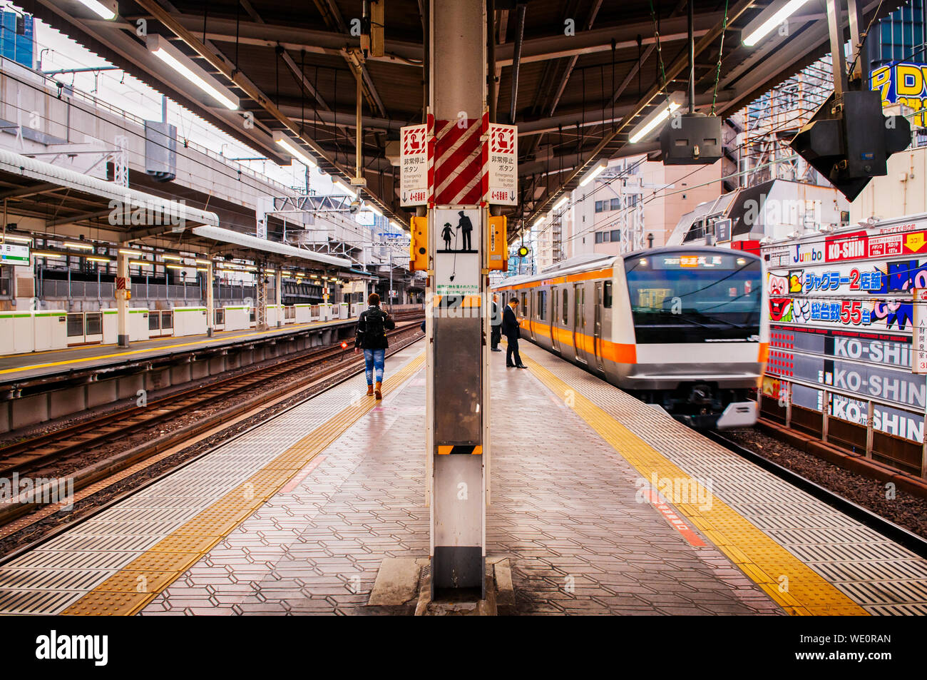 DEC 5, 2018 Tokyo, Japan - JR Chuo Linie Zug approching Kanda Bahnsteig mit wenigen Passagiere warten hinter der gelben Linie. Stockfoto