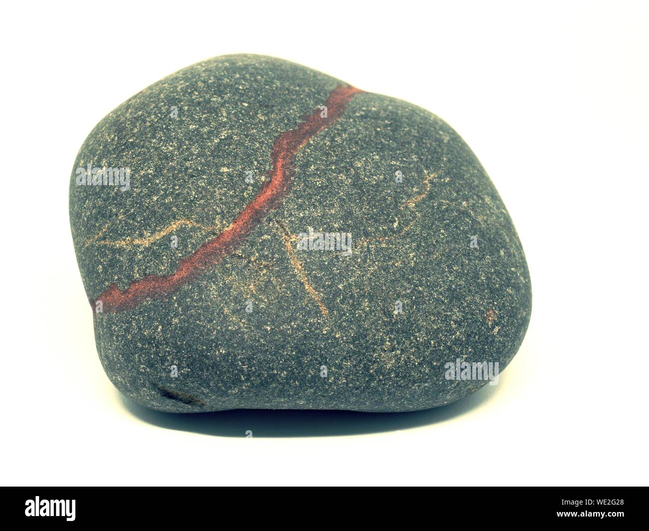 Makro Mineral Stein mit farbigen Adern auf einem weißen Hintergrund Nahaufnahme Stockfoto