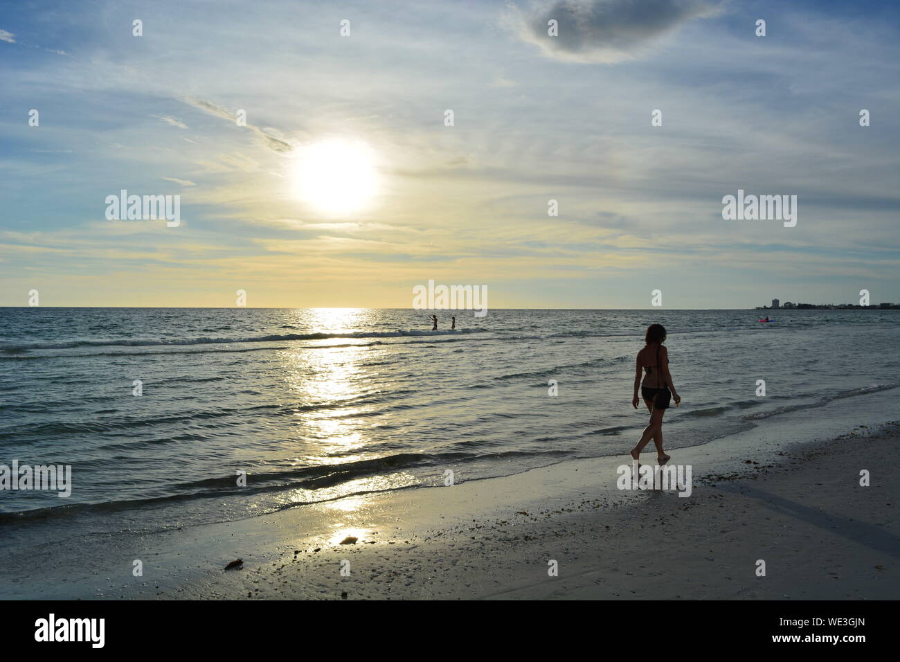 Eine Person zu Fuß am Strand bei Sonnenuntergang Stockfoto