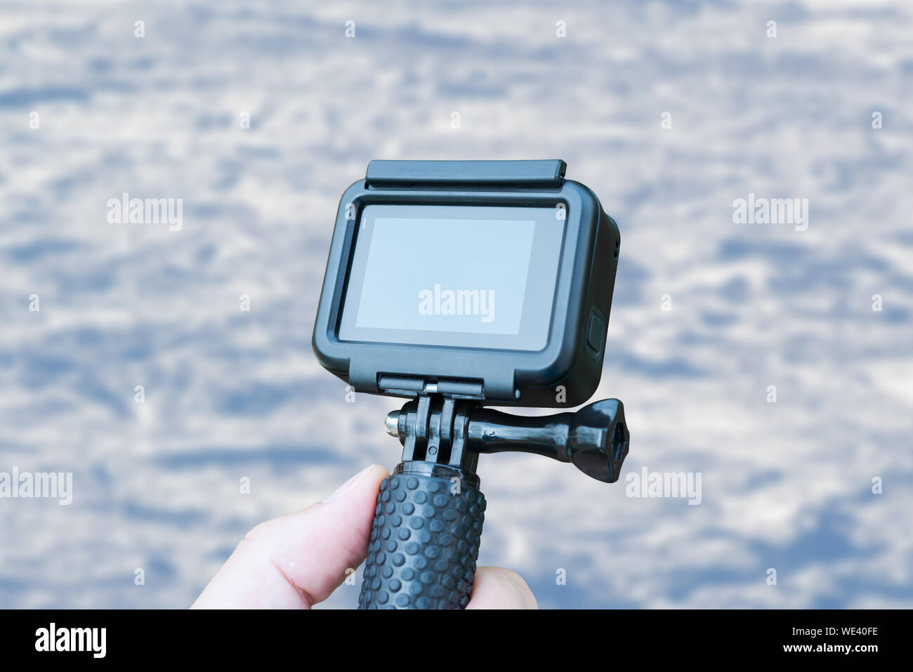 Action Kamera in der Hand auf Skifahren Konzept. Close Up. Leerer Bildschirm für mockup. Schnee im Hintergrund. Stockfoto