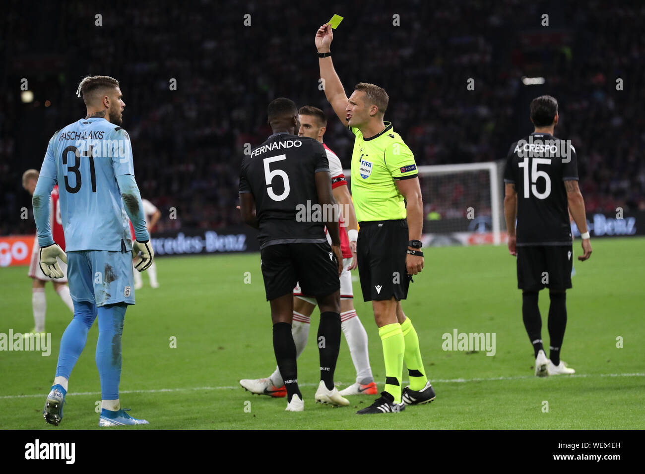 13. august 2019 Amsterdam, Niederlande Soccer Champions League Ajax / PAOK Saloniki 13-08-2019: Voetbal: Ajax / PAOK Saloniki: Amsterdam l-r: Alexandros Paschalakis von PAOK Saloniki, Fernando Varela von PAOK Saloniki, Schiedsrichter Craig Pawson, Jose Angel Crespo von PAOK Saloniki. Gelbe Karte Alexandros Paschalakis von PAOK Saloniki Stockfoto