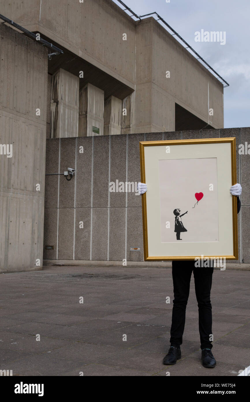 London, Großbritannien. 30 Aug, 2019. Der Christie Mitarbeiter wirft mit Kunstwerken" Mädchen mit Ballon" durch anonyme Street Artist Banksy an der Southbank Centre in London Freitag, 30. August 2019. Die Southbank Centre wurde in der Nähe einer der ursprünglichen Standorte die Kunstwerke in London erschien. Die Drucke werden auf Verkauf nur während einer Online Auktion mit dem Titel 'Banksy: Ich kann nicht glauben, dass sie Idioten dieser Sh*t" von Christie's Auktionshaus zwischen 11-24 September 2019 vorgestellt. Foto Credit: Lukas MacGregor/Alamy leben Nachrichten Stockfoto