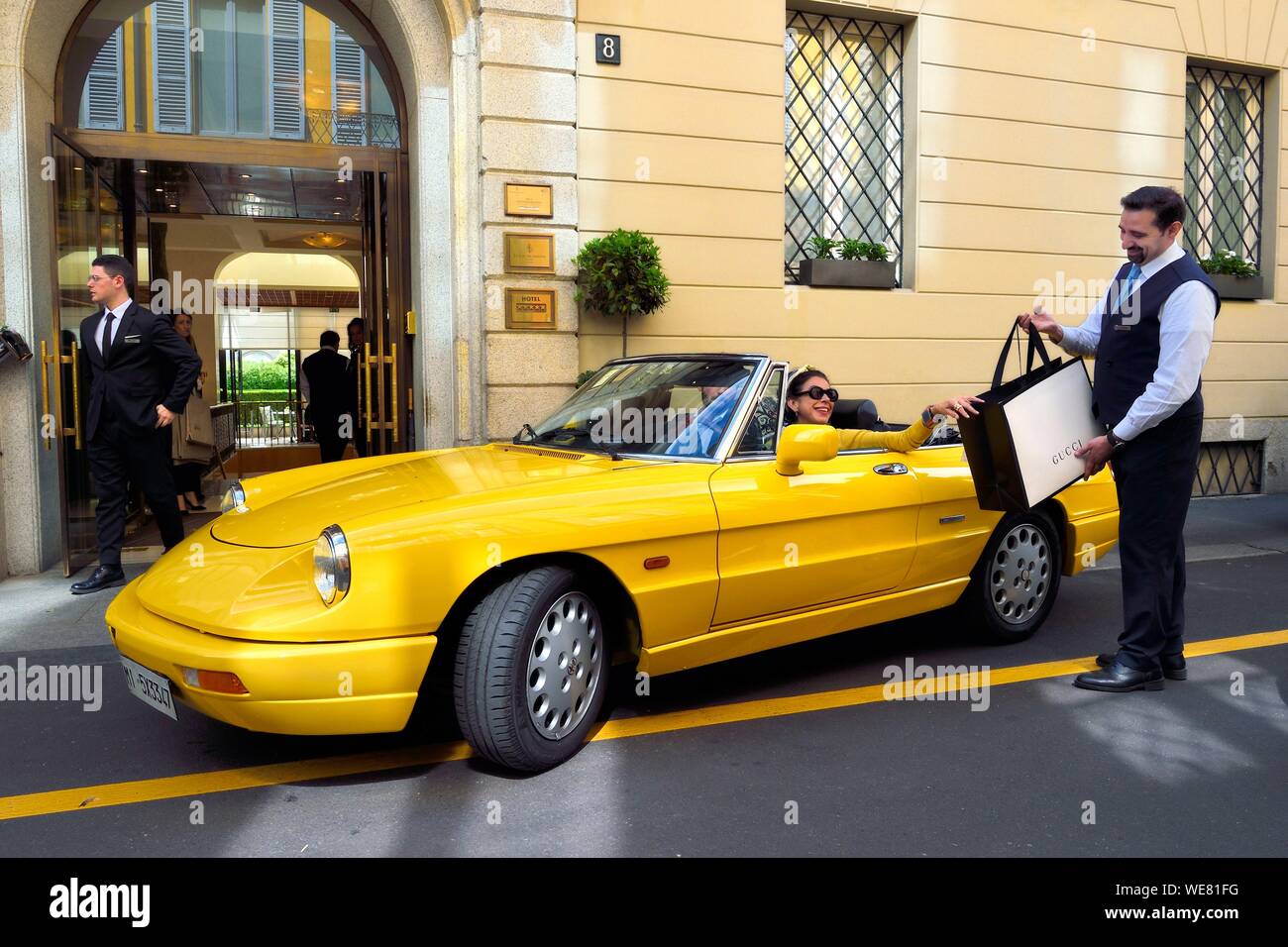 Italien, Lombardei, Mailand, Mode Viereck (Quadrilatero della moda), Alfa Romeo Duetto Spider gelb Cabrio vor dem Four Seasons Hotel Milano, der Portier bringt eine Gucci Tasche Stockfoto