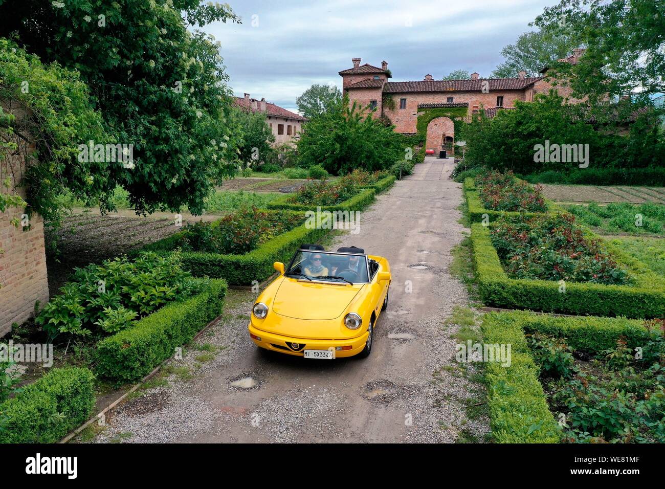 Italien, Emilia Romagna, Polesine Zibello in der Nähe von Parma, Antica Corte Pallavicina Hotel und Restaurant, Alfa Romeo Duetto Spider gelb Cabrio (Luftbild) Stockfoto
