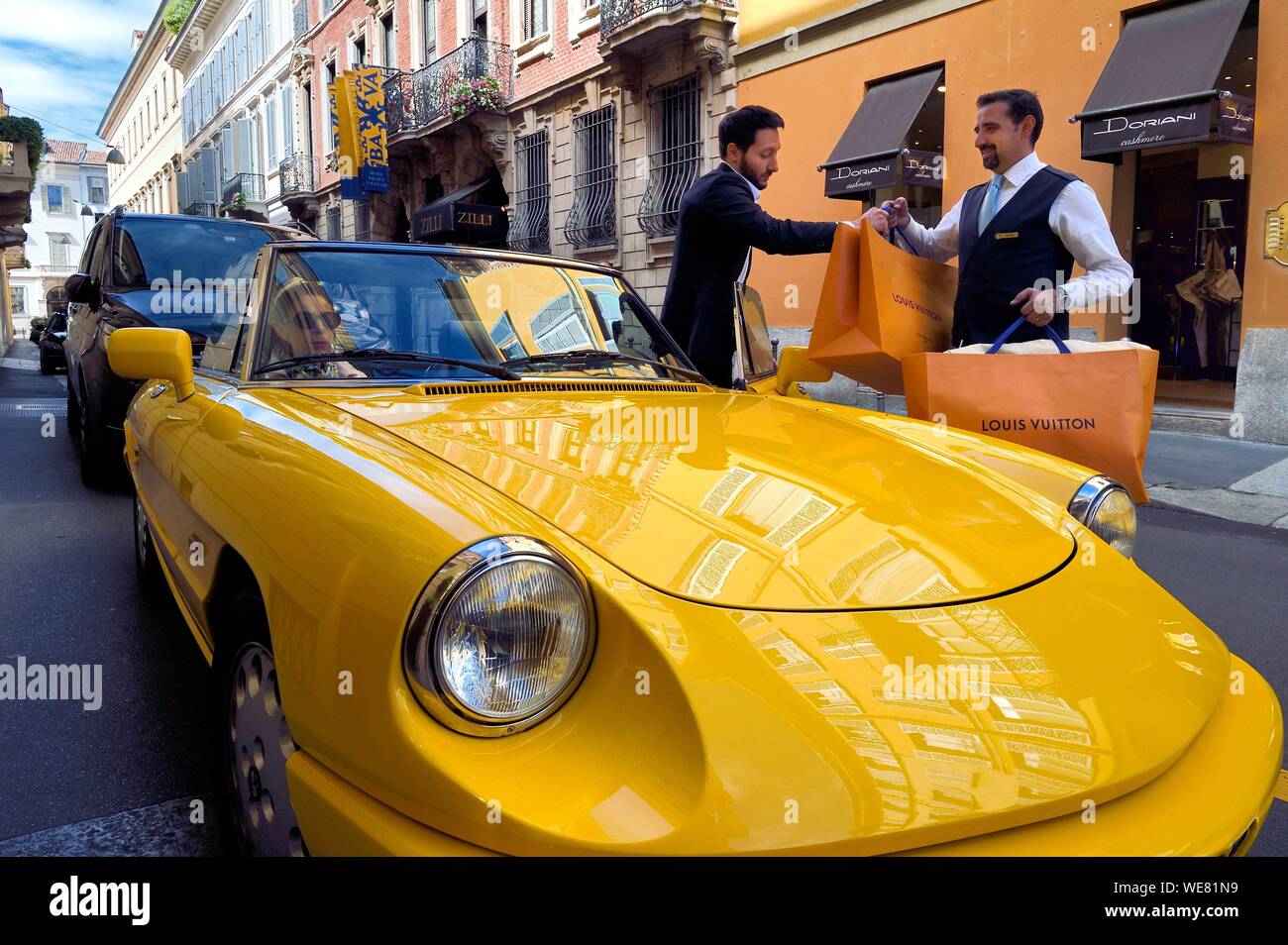 Italien, Lombardei, Mailand, Mode Viereck (Quadrilatero della moda), Alfa Romeo Duetto Spider gelb Cabrio vor dem Four Seasons Hotel Milano, der Portier bringt eine Vuitton Tasche Stockfoto