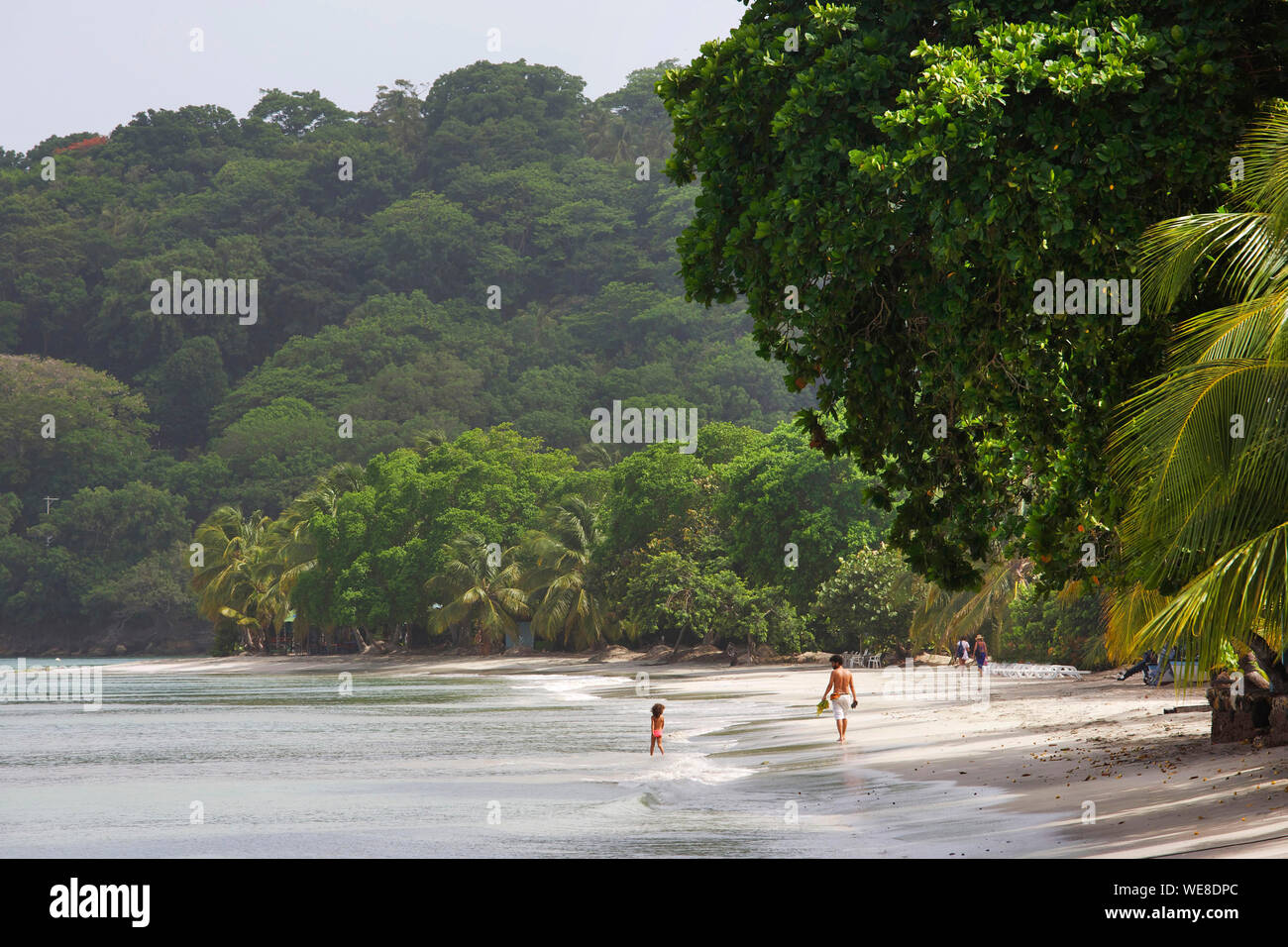 Kolumbien, Ziyaaraiyfushi, Centro Strand, Mann und seine kleine Tochter zu Fuß auf den Strand von Sureste umgeben von tropischer Vegetation und durch die Karibik getaucht Stockfoto