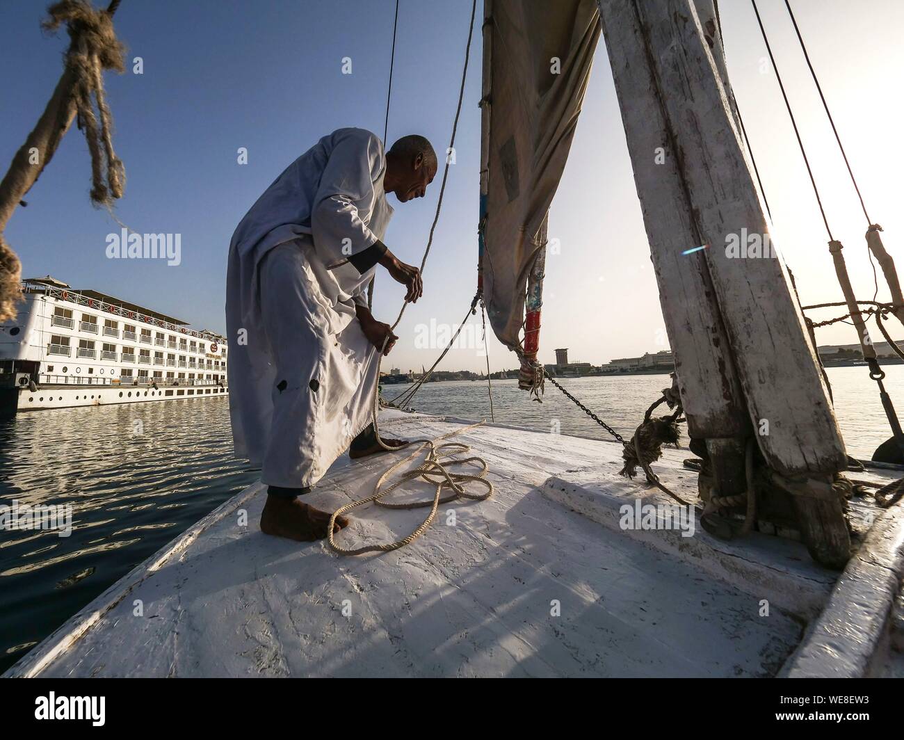 Ägypten, Ägypten, Nubien, Nil Tal, Assuan, an Bord einer Feluke, dem Kapitän faltet seine Segel vor dem Andocken Stockfoto