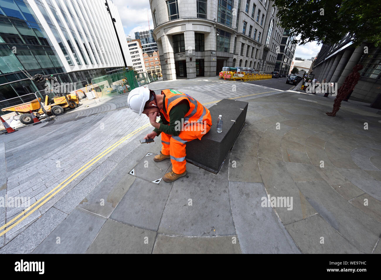London, England, UK. Bauarbeiter auf seinem Handy auf seine Pause, in der City von London Stockfoto