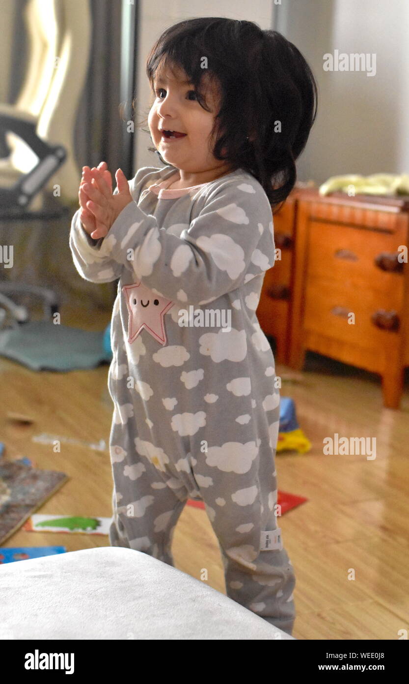 Cute Baby Mädchen lernt bis zu Stand: entwicklungsmeilensteine Stockfoto
