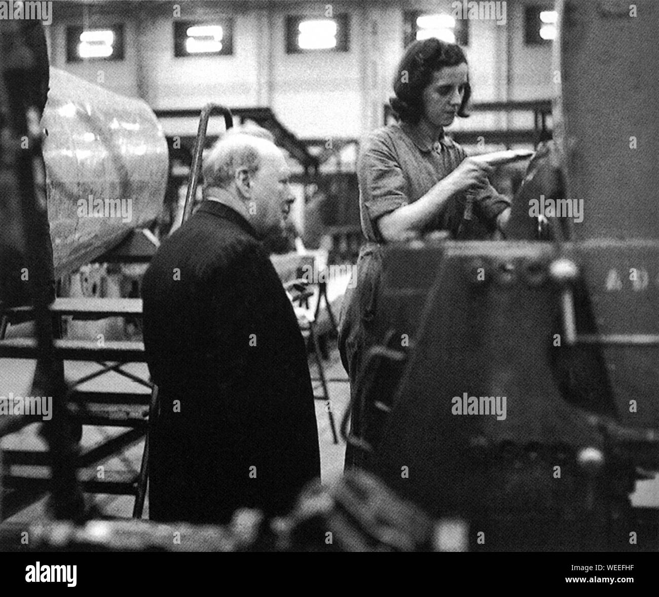Winston Churchill besucht bombenbeschädigte Städte. Hier sieht er einer Frau bei der Arbeit an einem spitfire-Flugzeug in einer Coventry.Factory zu. September 1941 Stockfoto