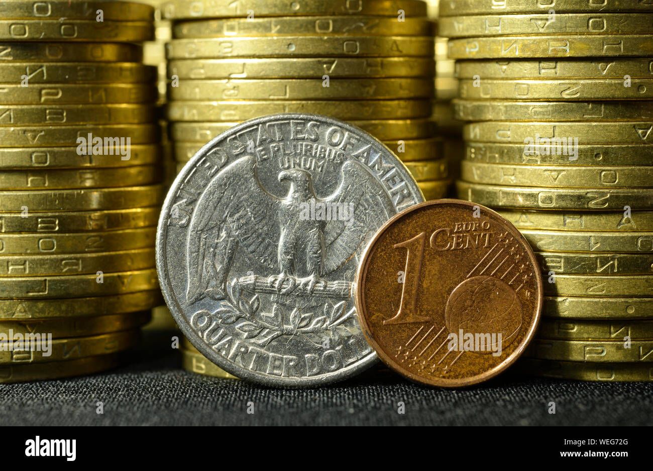 Quartal dollar Münze und ein Euro Cent Münze auf Kanten vor Stapel von Münzen platziert Stockfoto