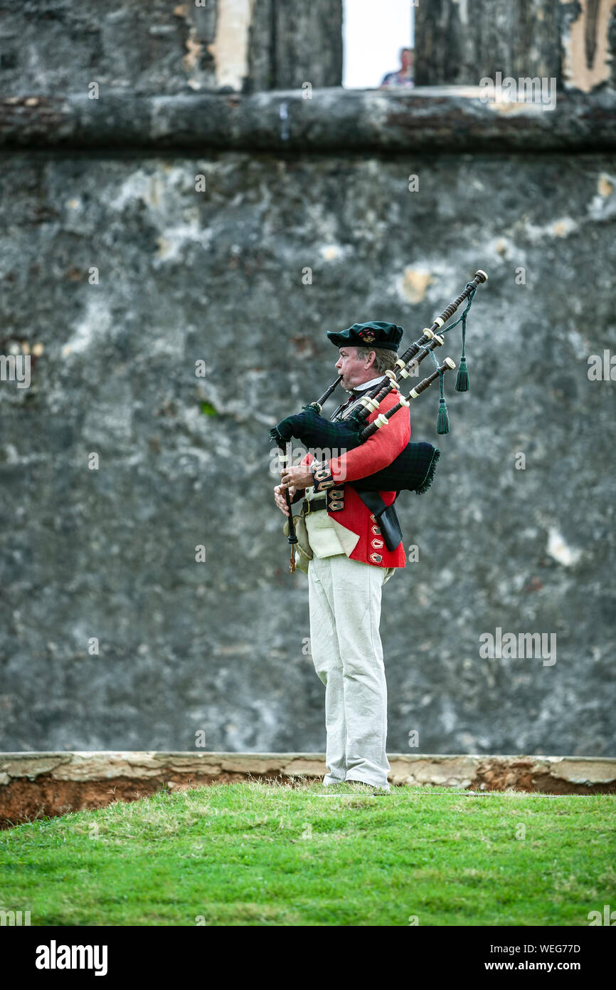 Militärische reenactor spielt Dudelsack in Ca. späten 1700s Uniform, San Felipe del Morro Castle (1540s-1786), San Juan National Historic Site, Old San Juan, Stockfoto