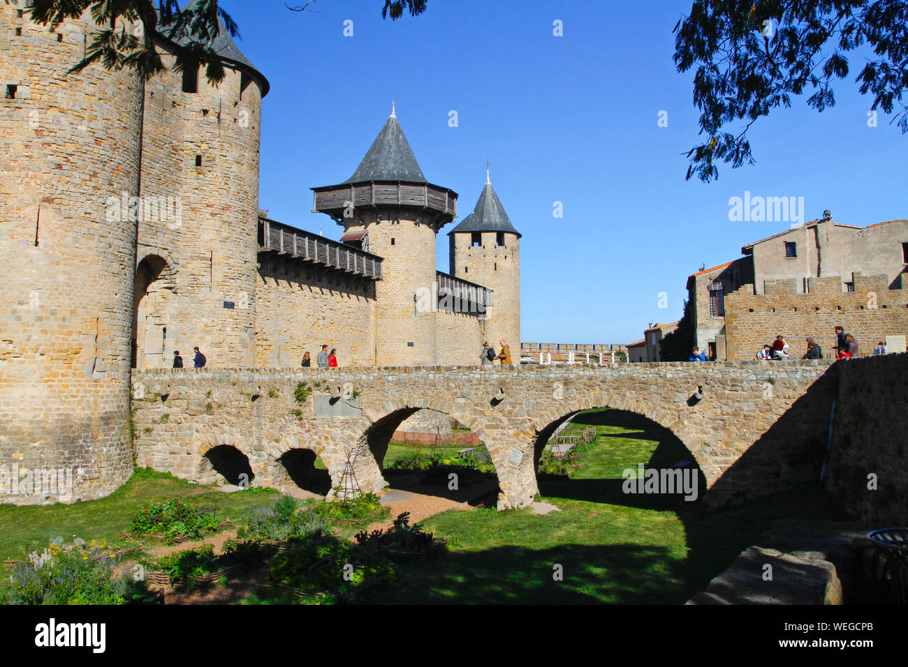 Carcassonne, Aude, Royal, Frankreich, Europa. 2014. Menschen gehen über die Bogenbrücke zu Comtal Schloss. Französisch Reiseziel mit sonnigen blauen Himmel Stockfoto