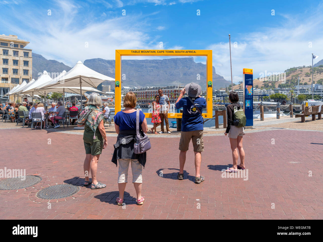 Touristen posieren für Fotos vor der Tafelberg, der V&A Waterfront, Cape Town, Western Cape, Südafrika Stockfoto