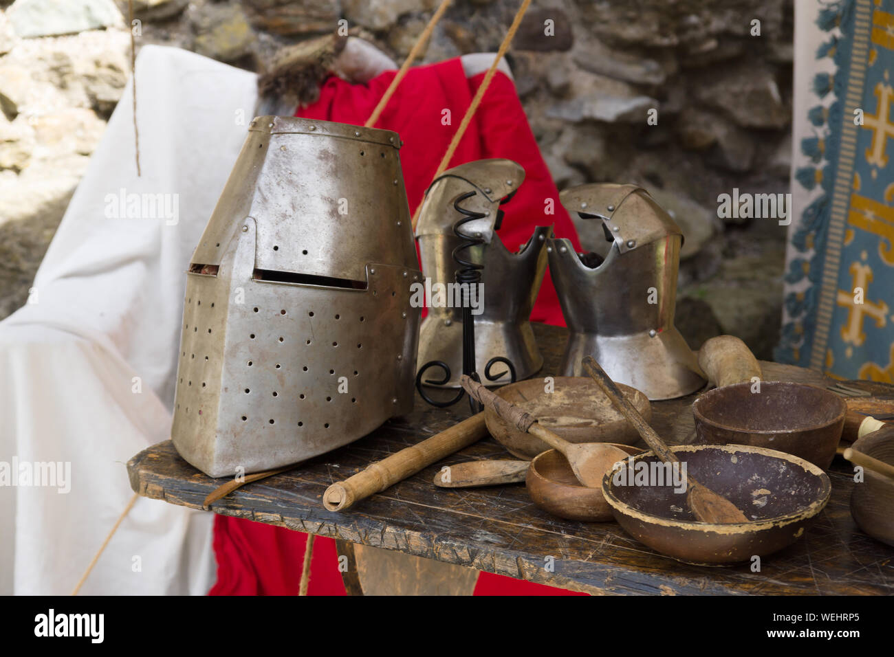 Mittelalterliche 12. Jahrhundert geschlossenen Helm oder großen Helm und Handschuhe mit Essgeschirr in einem Re-enactment Camp Stockfoto