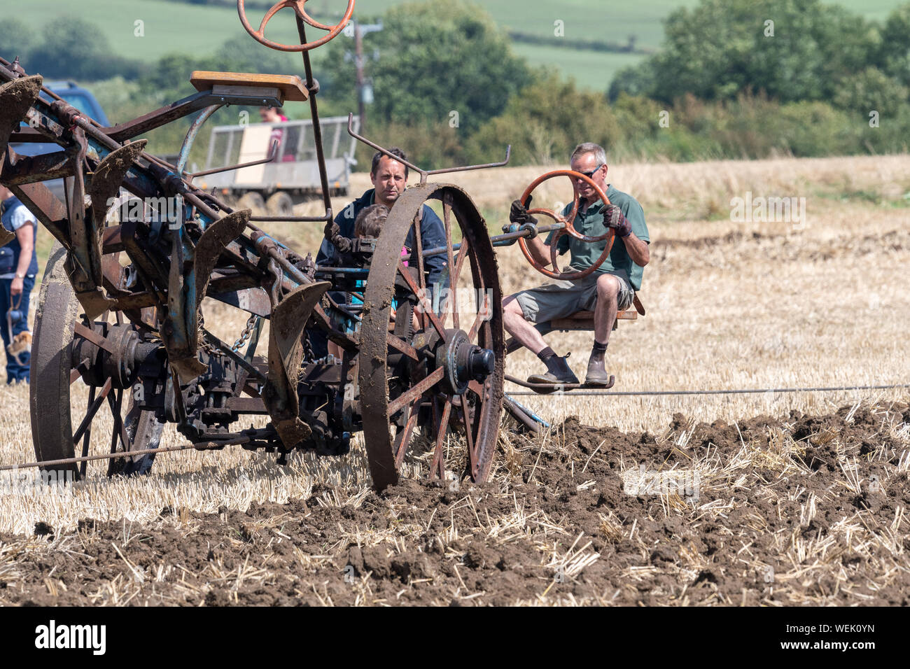 Haselbury Plucknet. Somerset. Vereinigtes Königreich. 18. August 2019. Ein Pflug wird über ein Feld von einer voll restaurierten alten Zugmaschine gezogen zu einem Stockfoto
