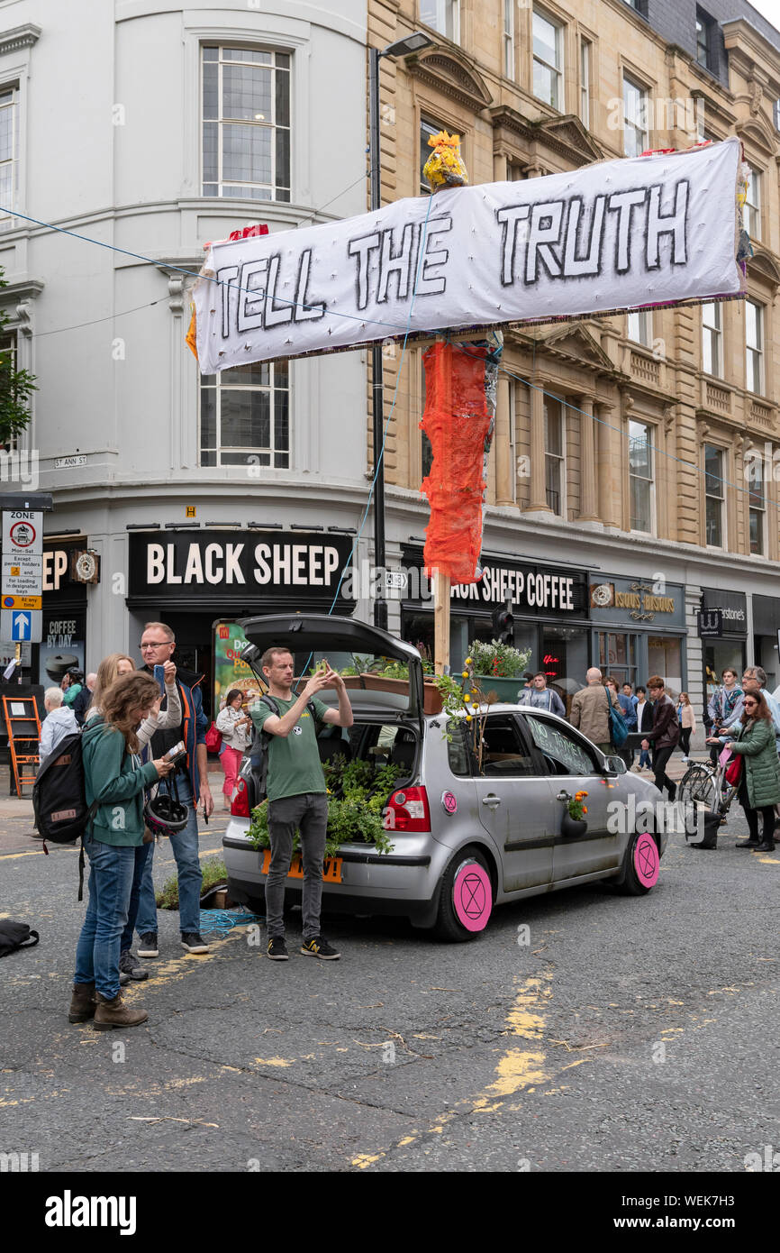 Klima protest Gruppe Aussterben Rebellion hält Protest Sperrung einer der belebtesten Straßen Manchesters Stadtzentrum - Deansgate. Stockfoto