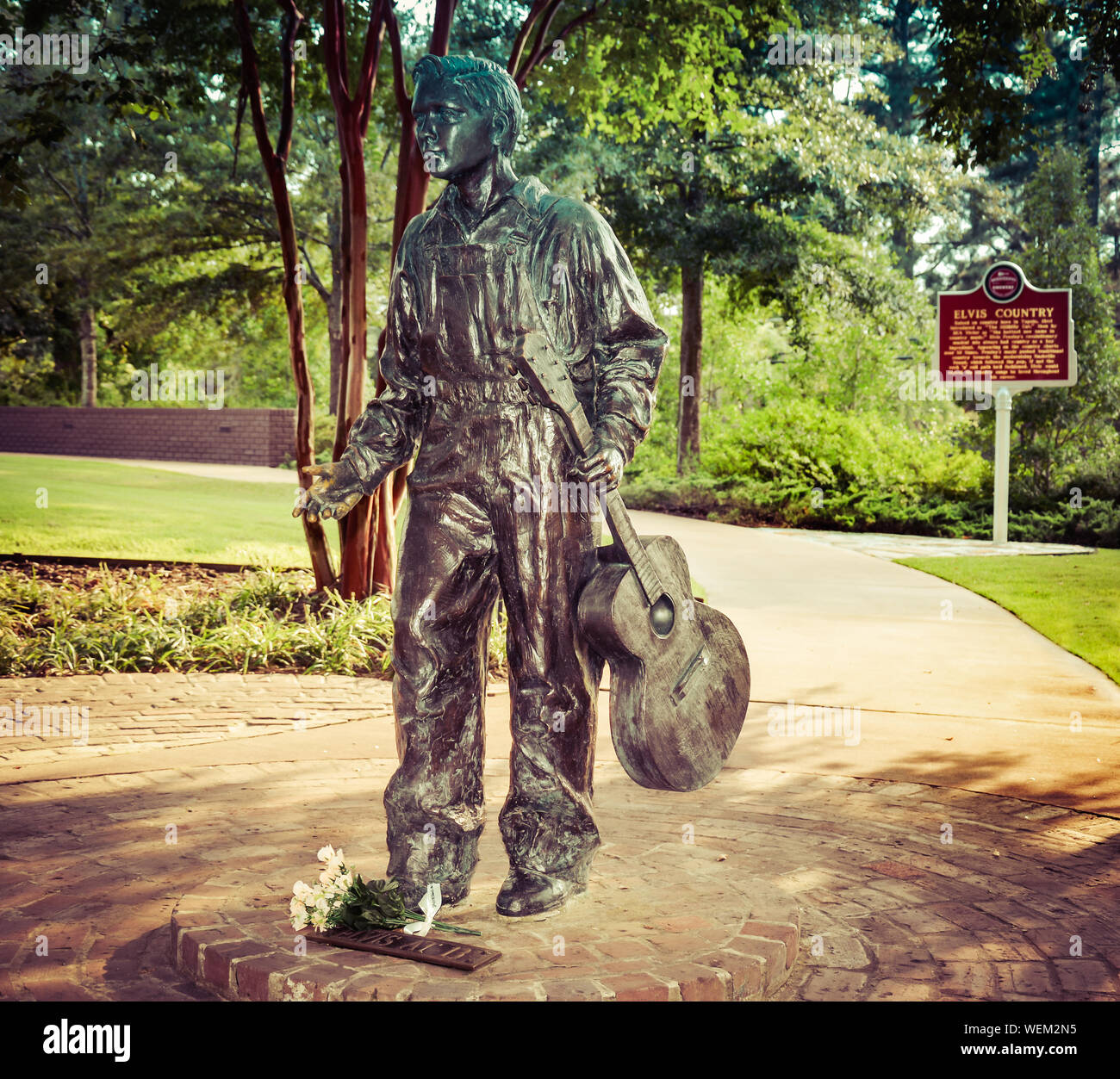 Eine Bronzestatue des 13 Jahre alten Elvis mit Gitarre steht auf dem Weg Besichtigung der Elvis Presley Birthplace Museum gründen in Tupelo, MS, USA Stockfoto