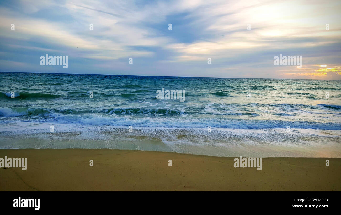 Tropical Beach Sonnenuntergang mit Welle im Meer bei Maichao Strand in Phuket City, Thailand Stockfoto