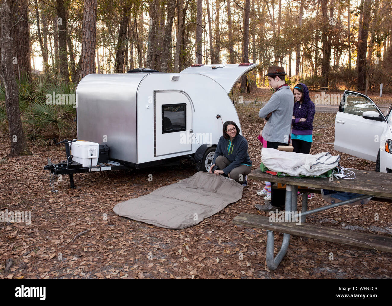 Family Camping mit teardrop Trailer im Wald Stockfoto