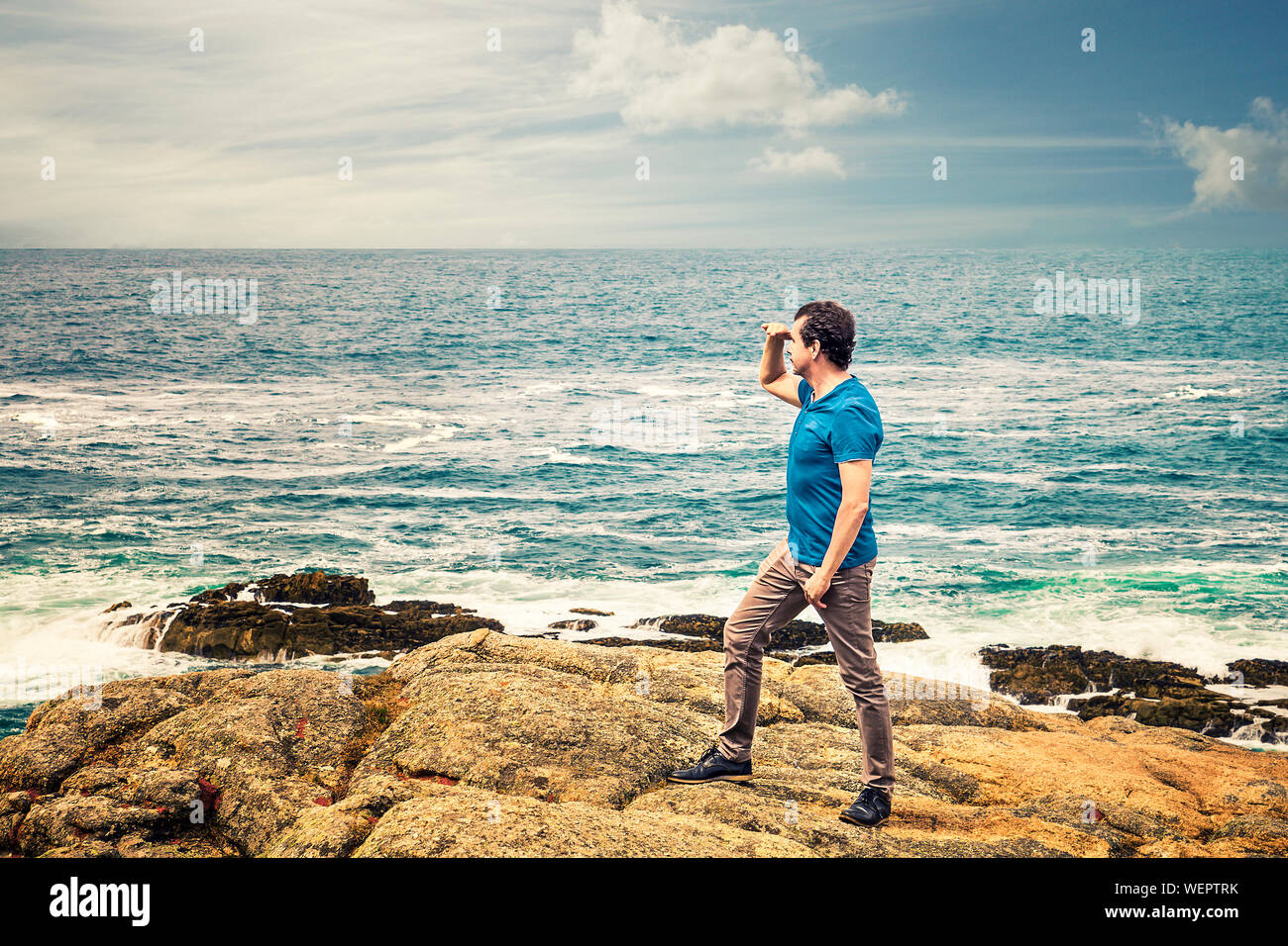 Mann in Freizeitkleidung neben dem Meer am Horizont suchen Stockfoto