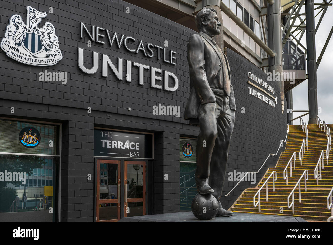 Eine Statue des legendären Sir Bobby Robson steht auf einem Sockel außerhalb der südwestlichen Ecke von St. James' Park, Newcastle, Nordengland. Stockfoto