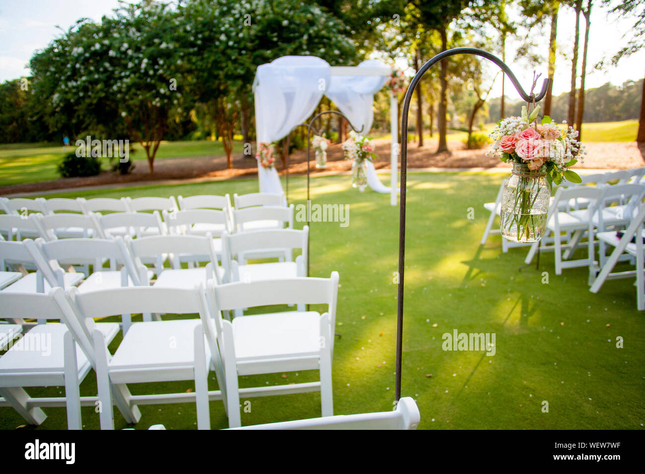 Stühle und Arbor mit hängenden Blumen für Hochzeit, auf Blumen im Glas Fokus Stockfoto