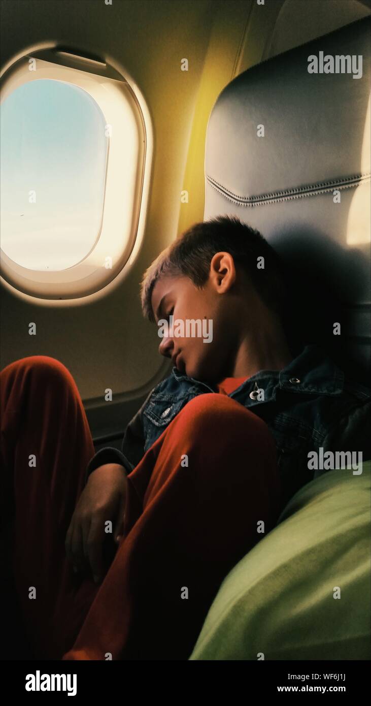 Junge Schlafen bei Reisen im Flugzeug Stockfoto