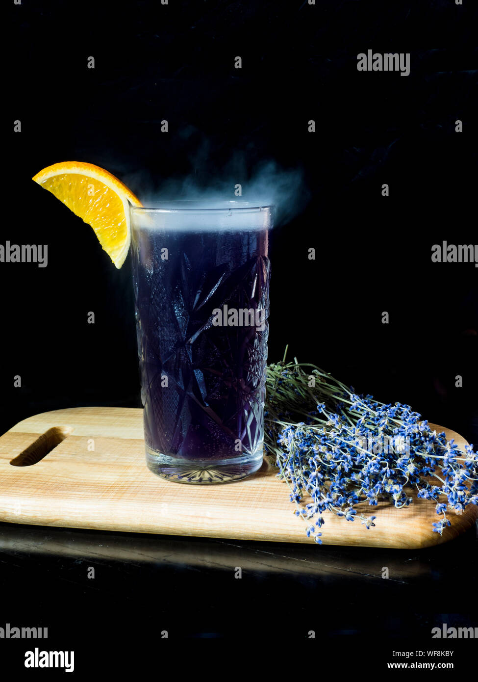 Close-up von Dampf auf Lavendel Limonade am Tisch auf schwarzem Hintergrund Stockfoto