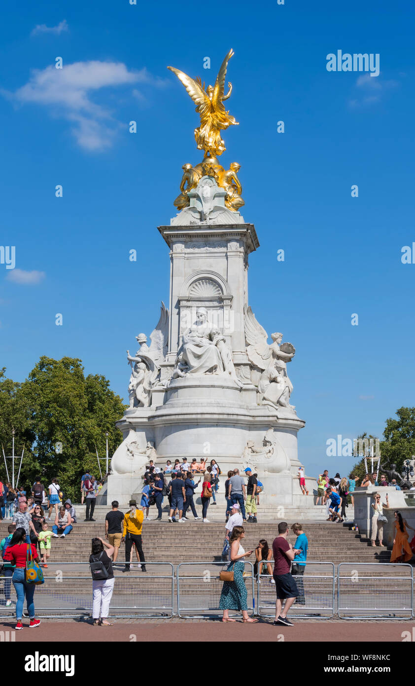 Touristen an der goldenen Statue auf der Queen Victoria Memorial am Buckingham Palace, Westminster, London, England, UK. Stockfoto