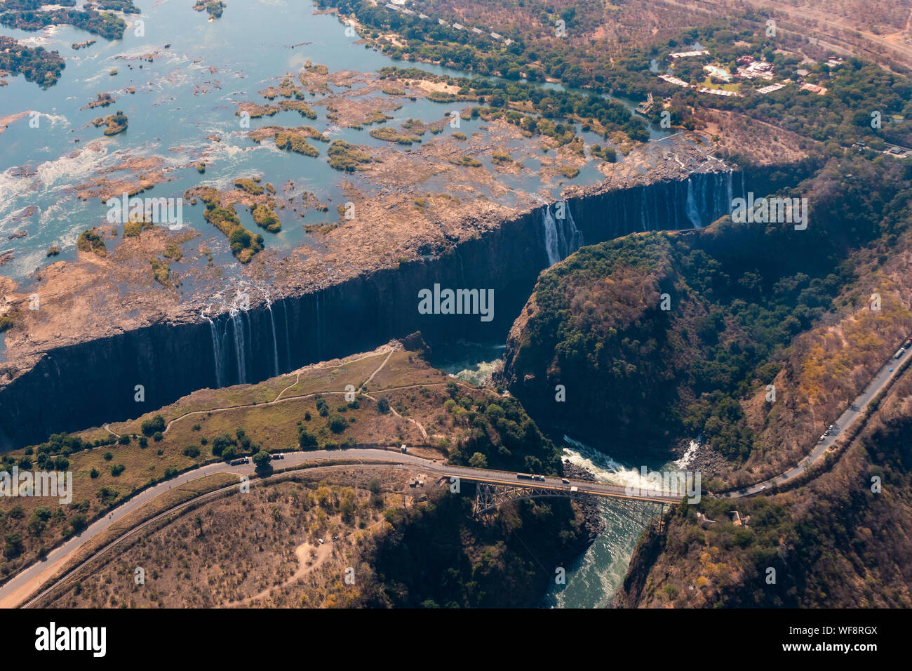 Spektakuläre Luftaufnahmen von Victoria Falls Wasserfall und der Brücke über den Sambesi, Simbabwe, Afrika Stockfoto