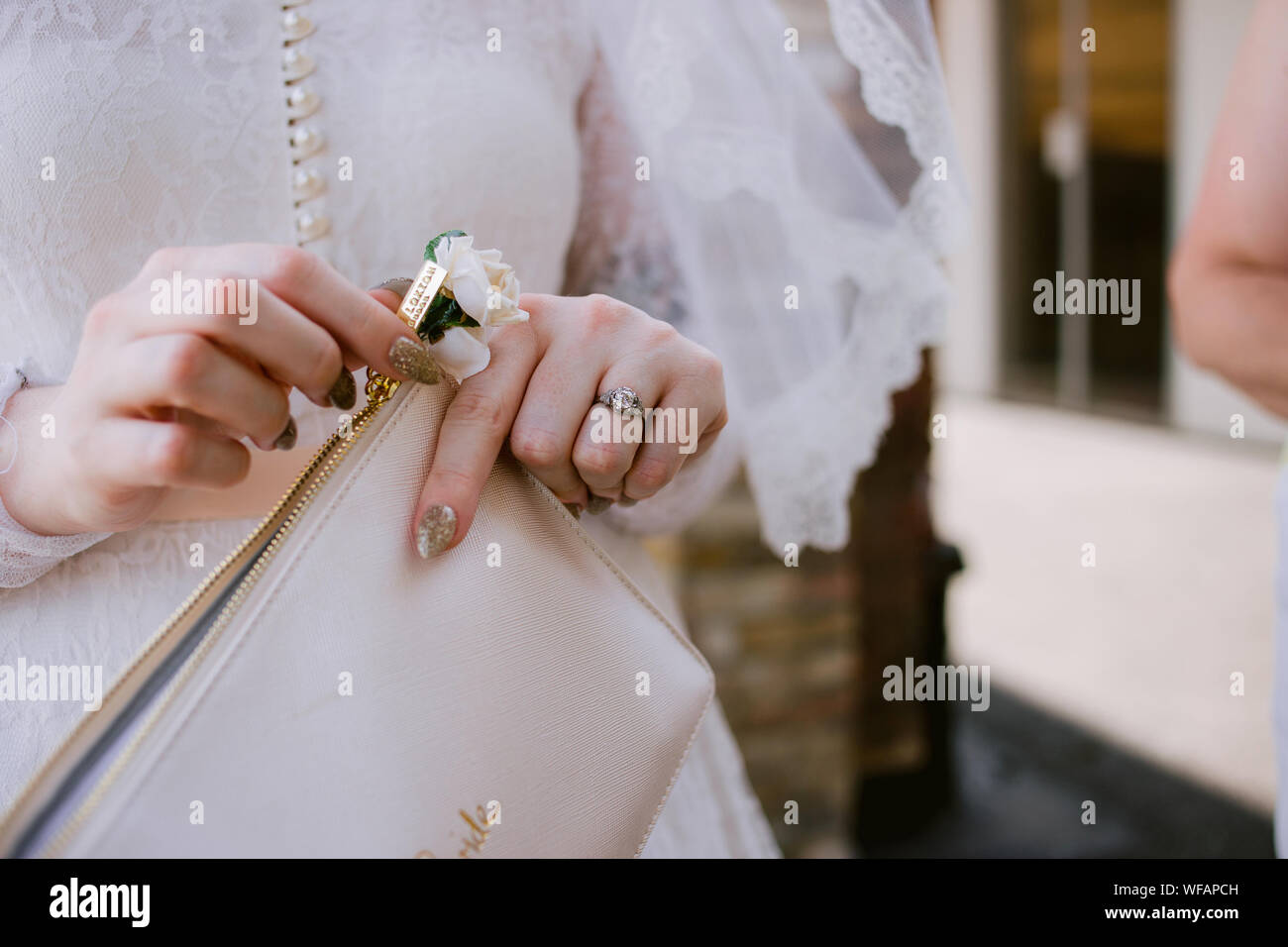 Detail der Frau an ihrem Hochzeitstag, die ihre Tasche mit ihrem Trauring sichtbar hält Stockfoto